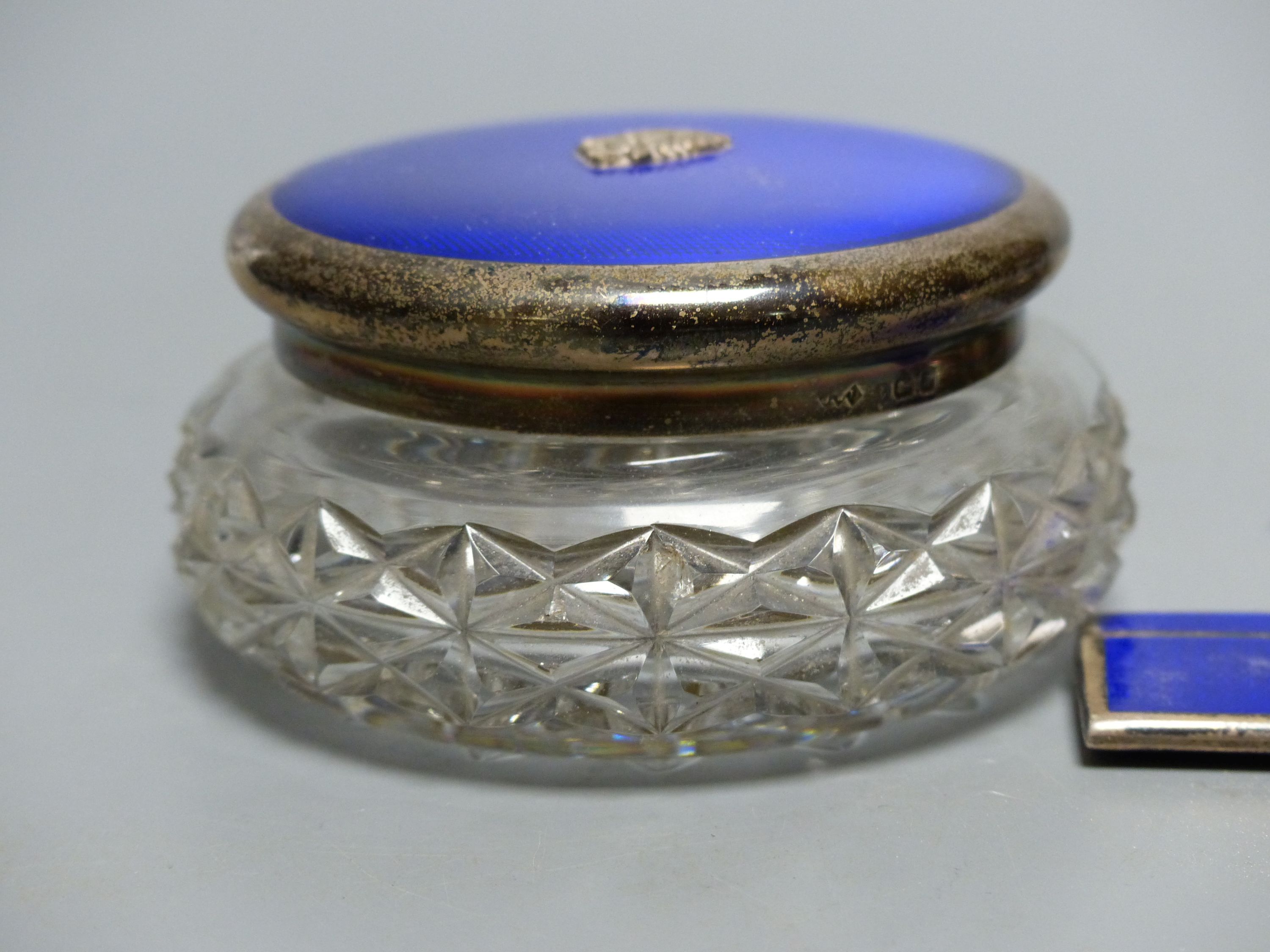 A 1930's four piece silver and blue enamel dressing table set, including , timepiece, powder jar, compact & comb,